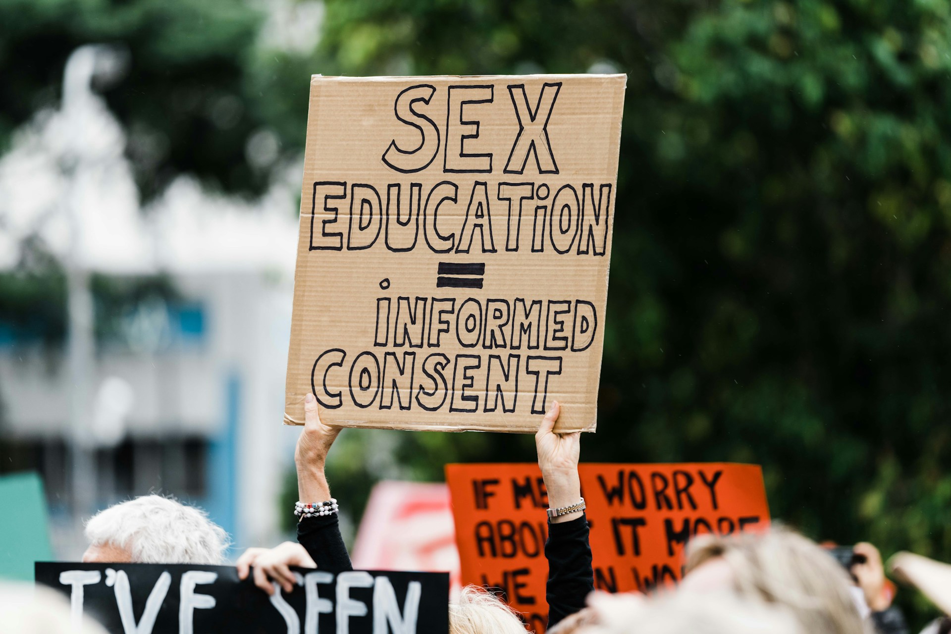 Kobieta trzyma tabliczkę z napisem "sex education = informed consent'