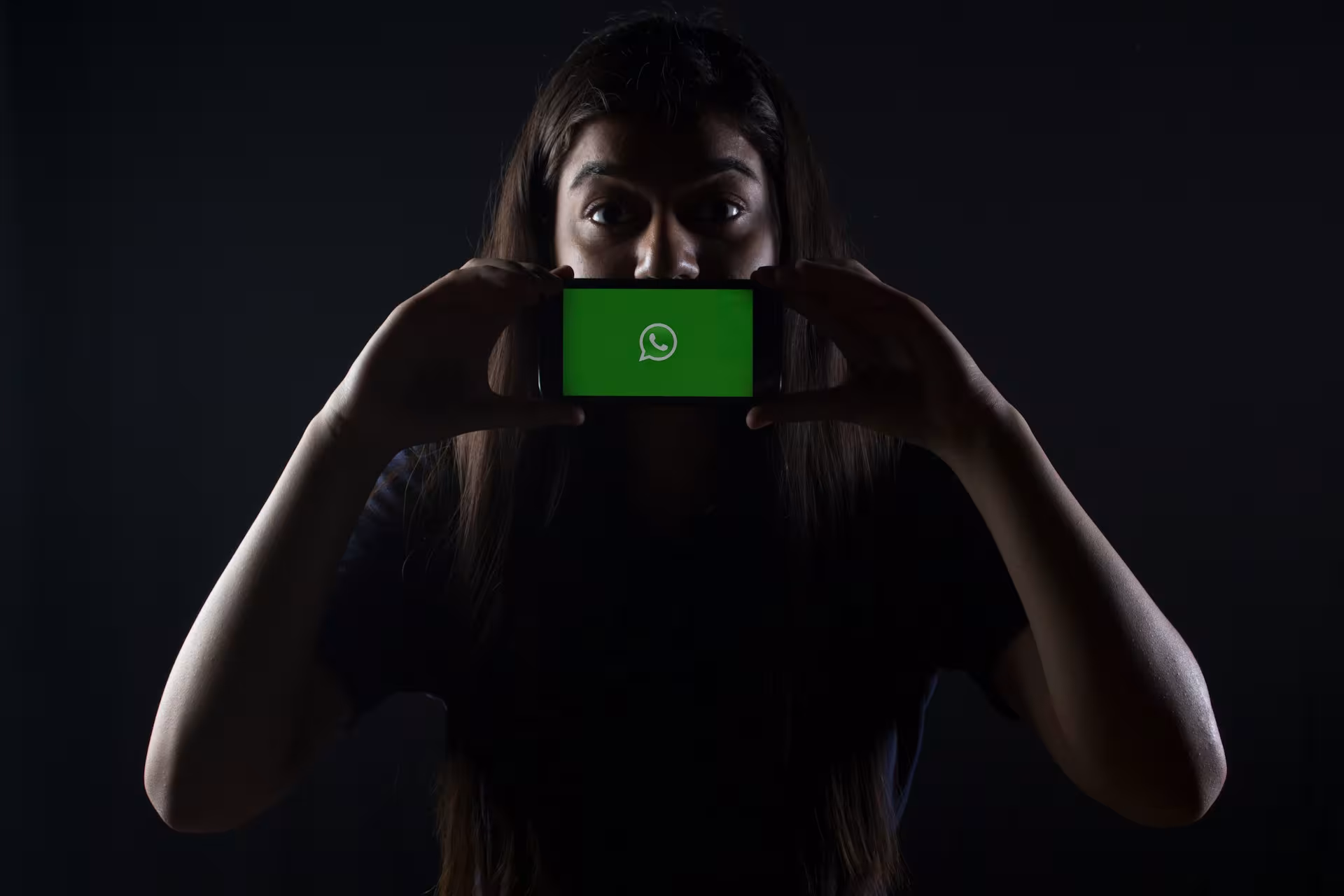 Kobieta, zamiast ust telefon z otwartym komunikatorem Whatsapp