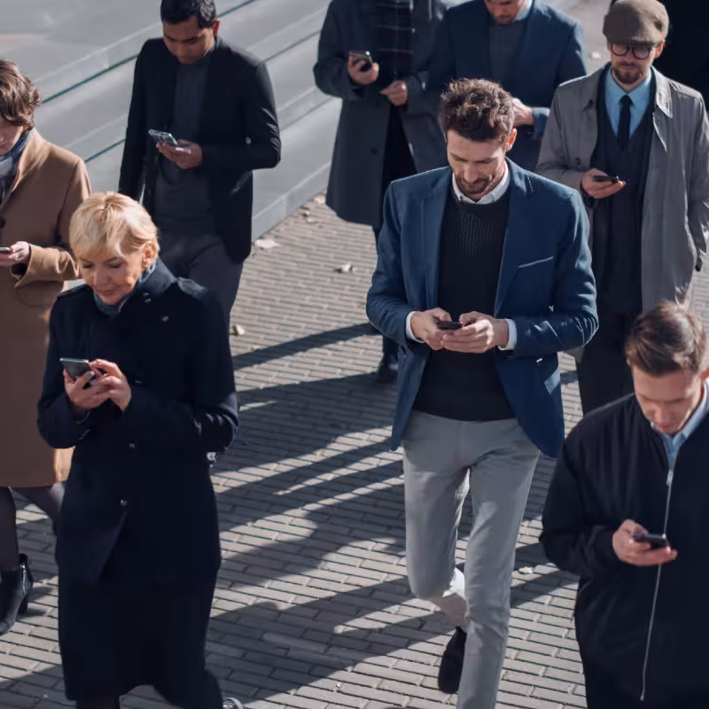 Tłum na ulicy, wszyscy wpatrzeni w telefony komórkowe
