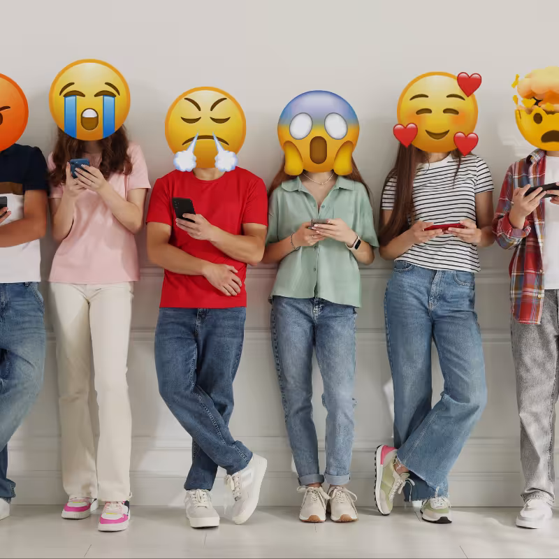 Zdjęcie przedstawiające sześcioro nastolatków wpatrzonych w telefony komórkowe, ich twarze zamienione na emotikony